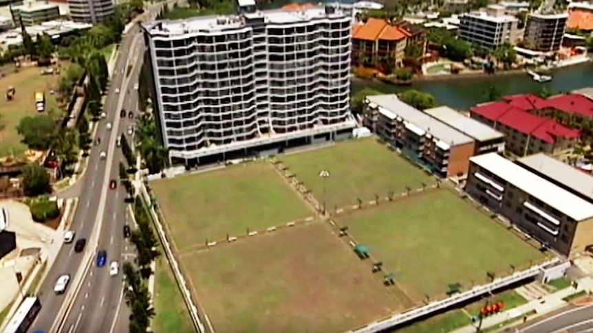Aerial view of a green surrounded by buildings.