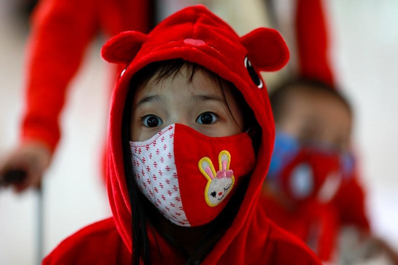 A child wears a red facemask.