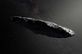 Illustration of Oumuamua that looks like a roughly cigar-shaped, elongated rocky object depicted in space.