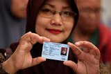 A woman holding her Indonesian identity card