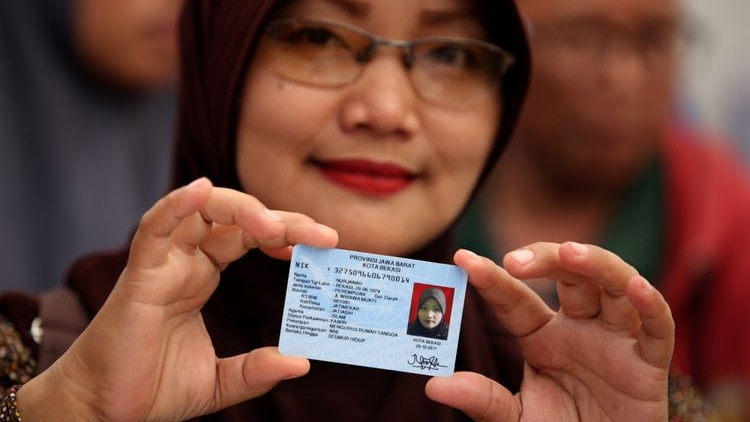 A woman holding her Indonesian identity card