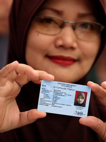 A woman holding her Indonesian identity card