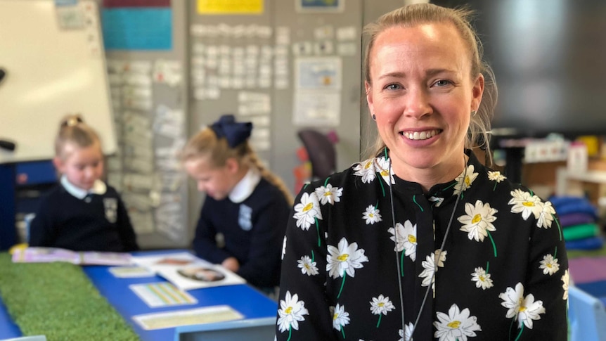 Stroke victim and teacher Rebecca Hands smiles for the camera with her two children in a classroom in Canberra.