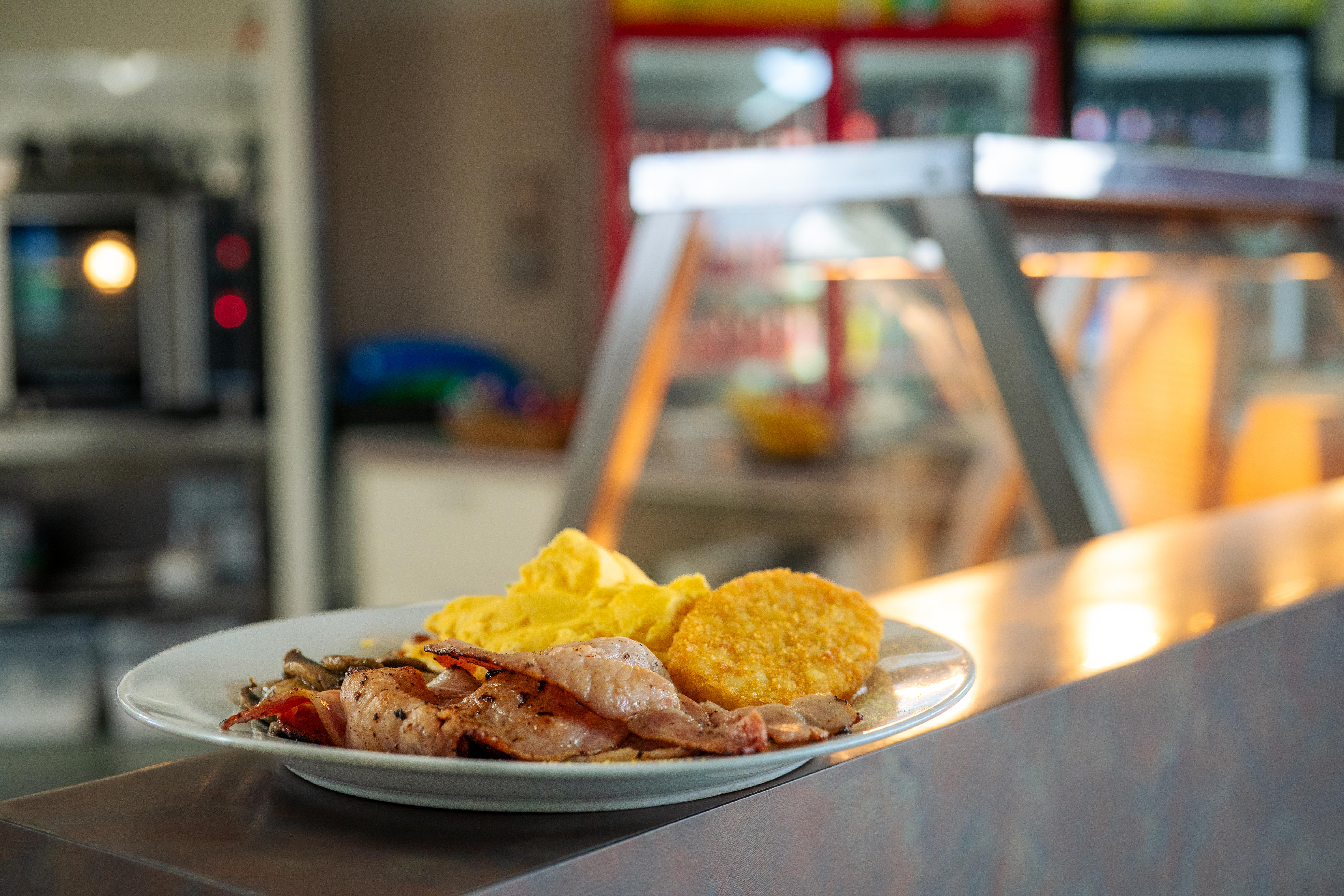 Un plato con huevo, tocino y croquetas de patata sobre una encimera.