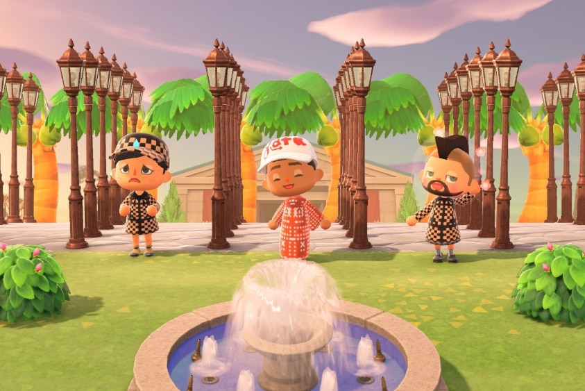 Three 3D characters in patterned outfits stand near fountain and in front of six rows of five cast iron street lamps and museum.