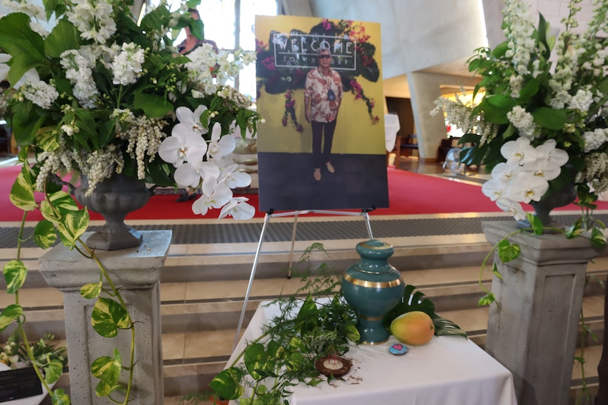 The memorial display at the funeral of well-known Darwin resident Ernie Chin, including a large photo of him and flowers.
