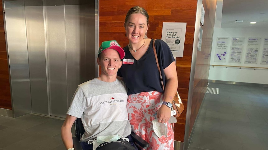 a man in a wheelchair and a woman standing next to him.