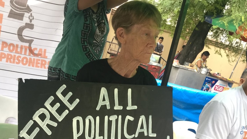 Patricia Fox is carrying a sign that reads "free all political prisoners".