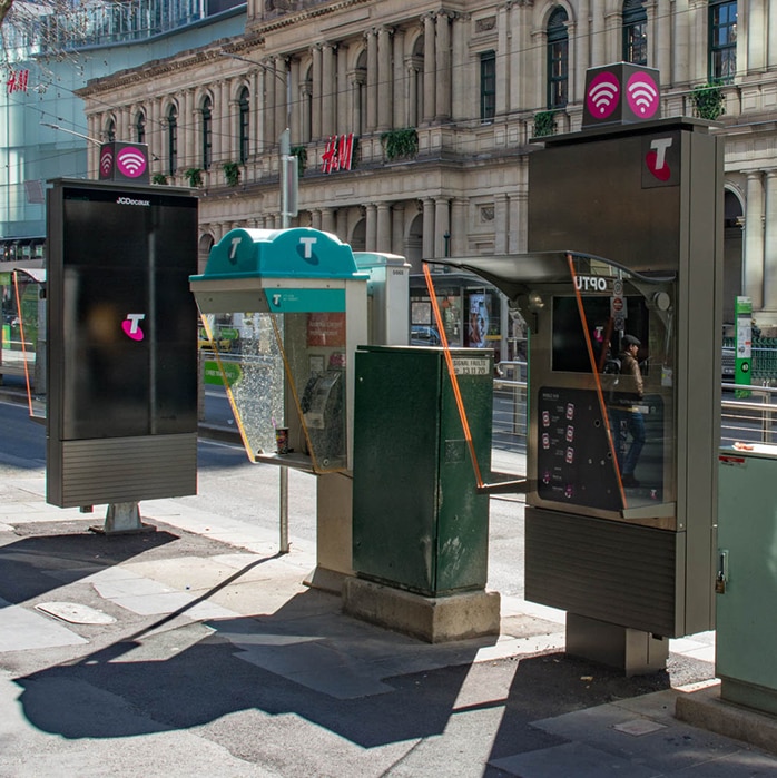 Two new payphones and one older payphone within five metres of each other on a CBD footpath.