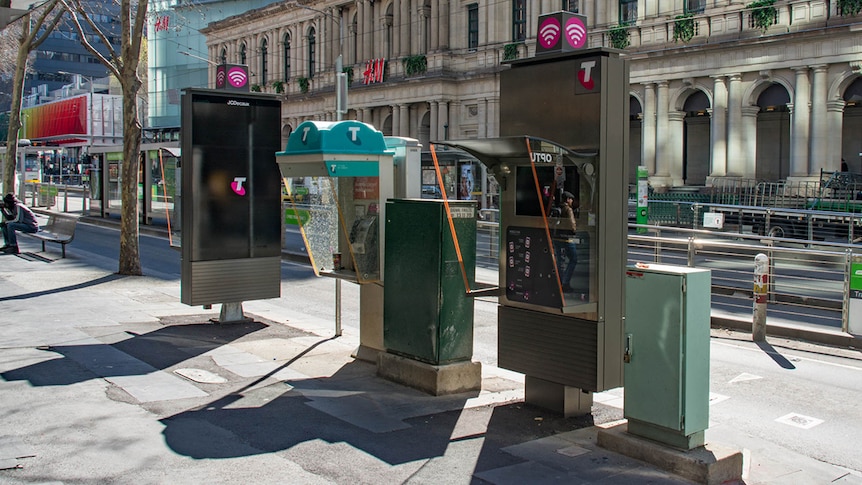 Two new payphones and one older payphone within five metres of each other on a CBD footpath.