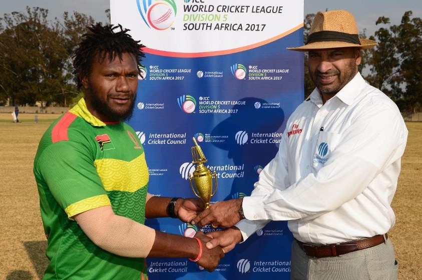 Patrick Matautaava shakes hands with an official as he is presented with a trophy.