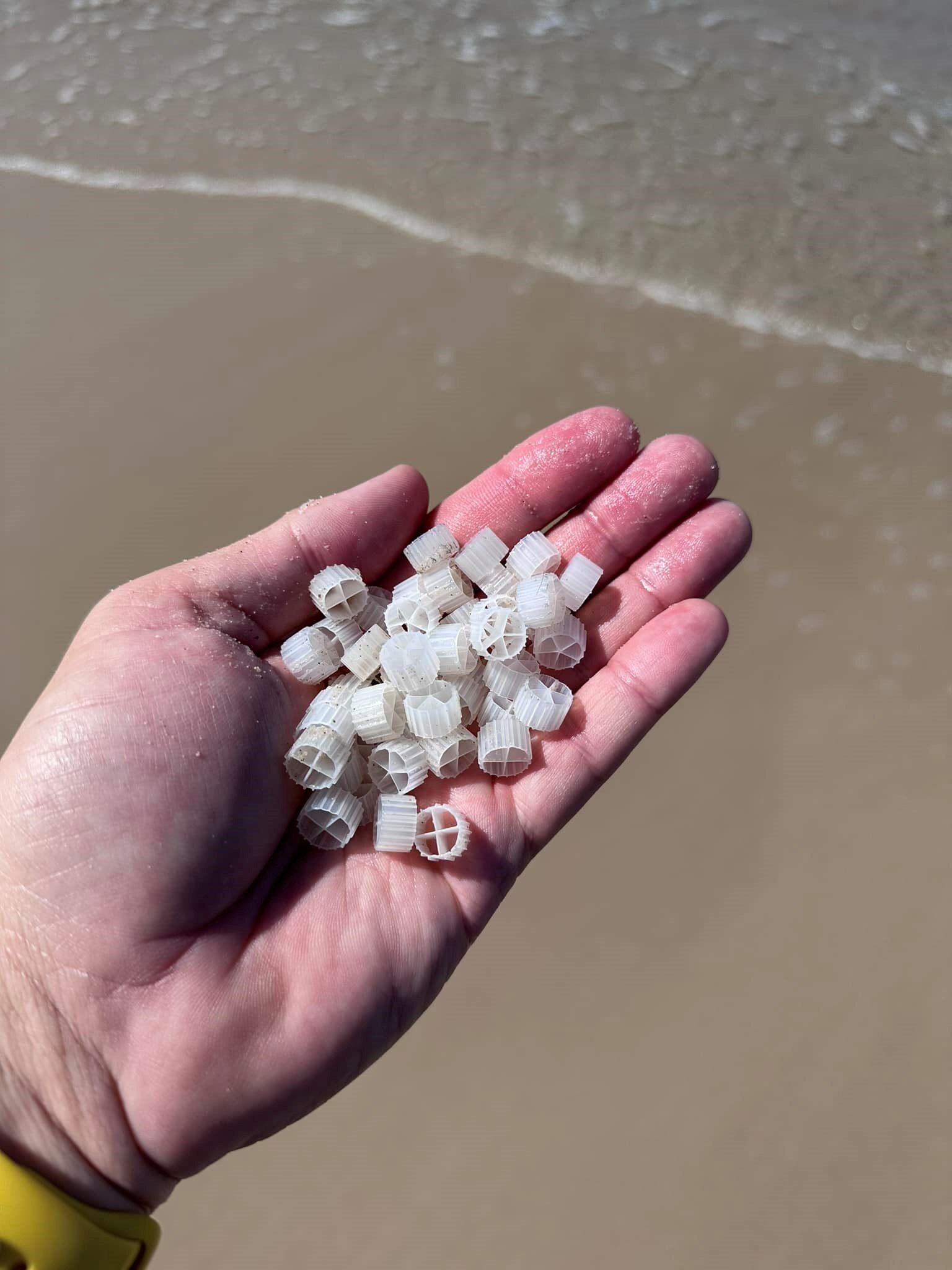 a hand holds bits of plastic 
