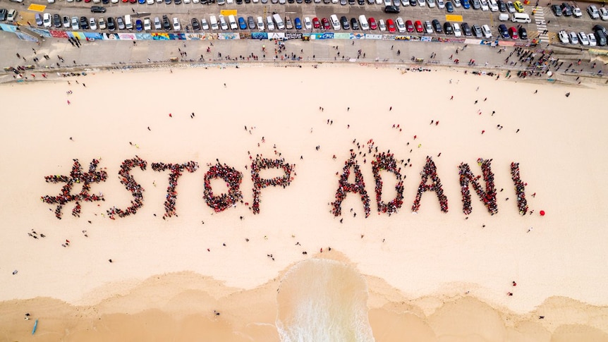 A Stop Adani sign formed by people on Bondi Beach.