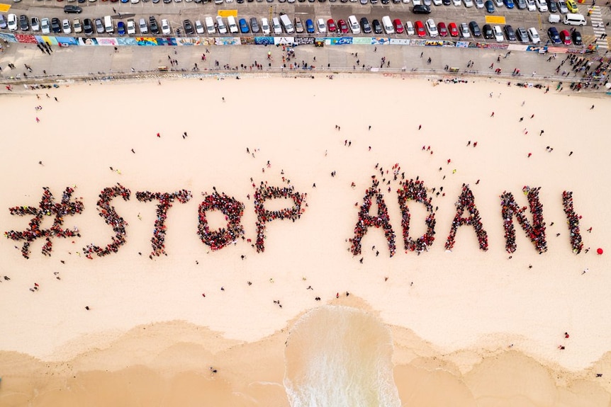 A Stop Adani sign formed by people on Bondi Beach.