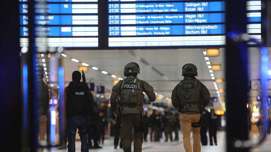 Special forces walk in the main train station in Dusseldorf following the axe attack.