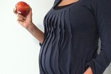 Pregnant woman with an apple in her hand
