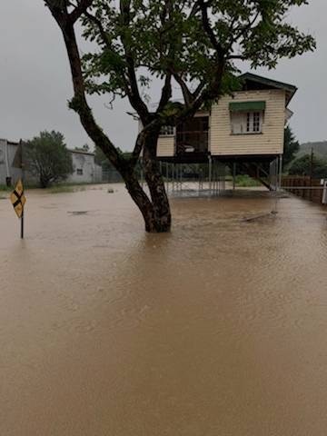 A house on stilts with floodwater below