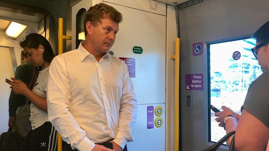 Chris Saunders stands on an overcrowded morning peak train service from Geelong to Melbourne.