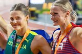 Nina Kenndy and Katie Moon stand arm in arm with gold medals around their necks