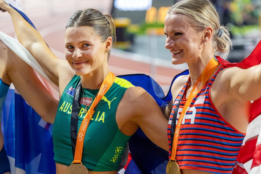 Nina Kenndy and Katie Moon stand arm in arm with gold medals around their necks