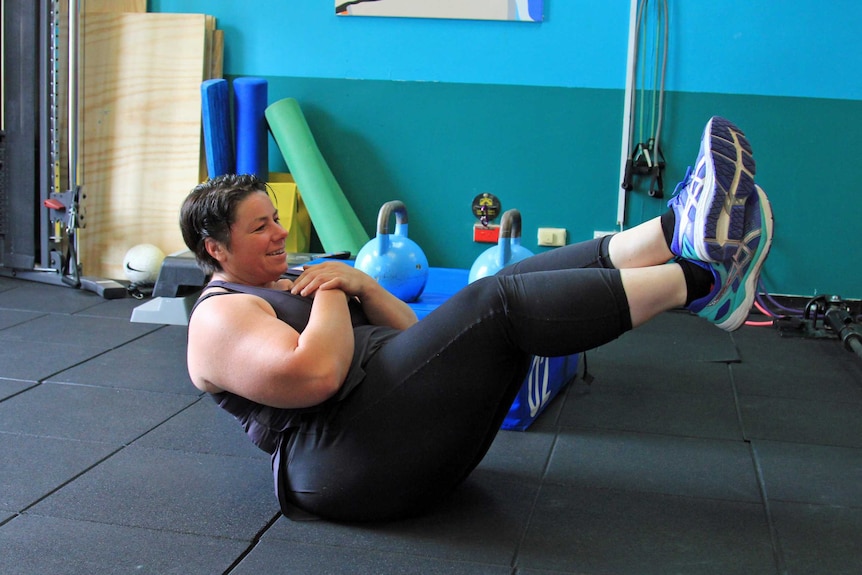 Woman in a static crunch hold on the floor