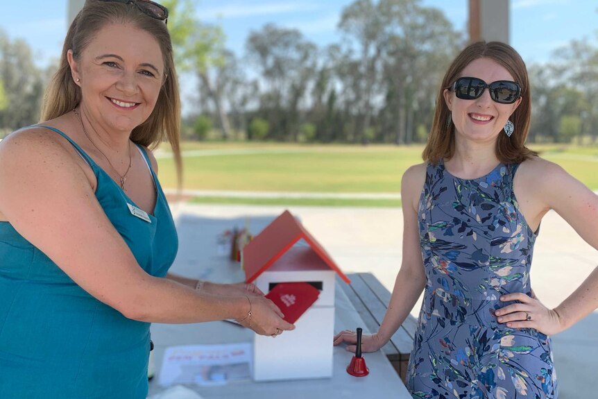 Pimpama women posing with a Santa mailbox where local children who make Christmas cards for aged care residents "post" them