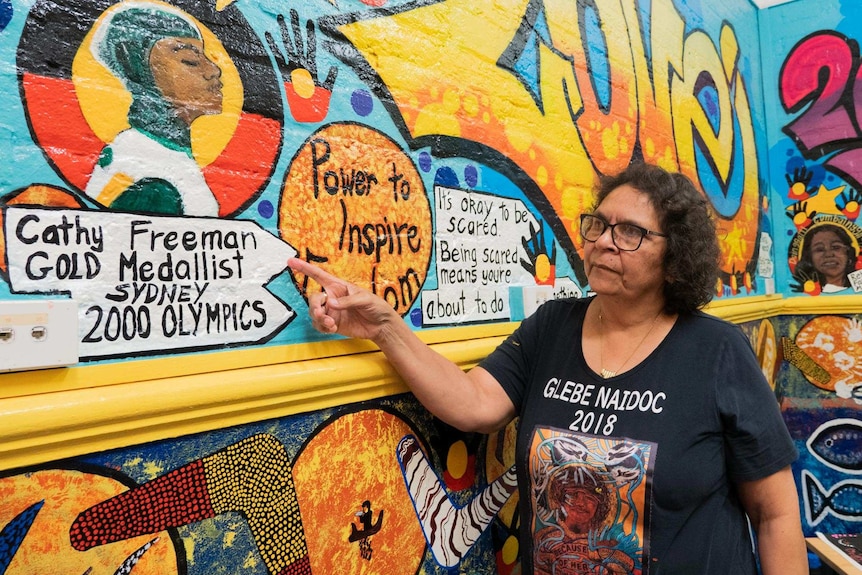 Aunty Kathryn Dodd Farrawell points to her mural at the Glebe Youth Service.