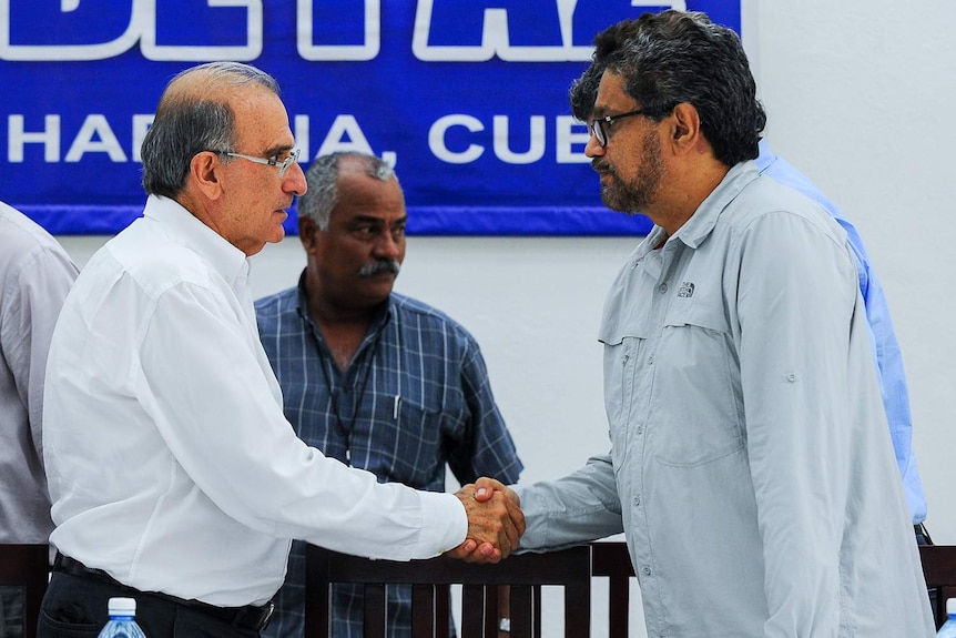 FARC guerilla commander and Colombian delegation head shake hands in Cuba