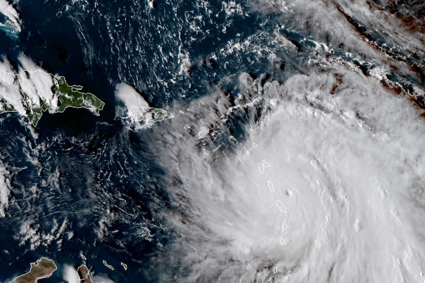 NASA satellite image of Hurricane Maria. It is a big white storm system.