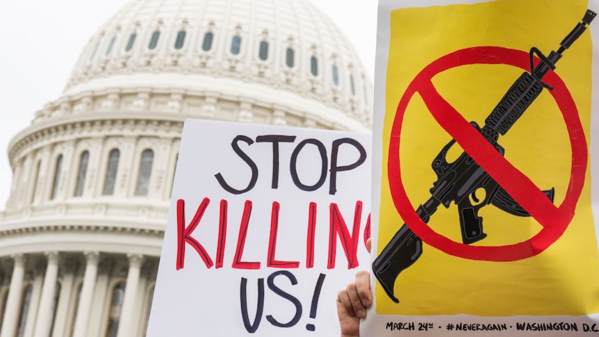 Demonstrators hold signs during a rally with senators outside the U.S. Capitol to demand the Senate take action on gun safety