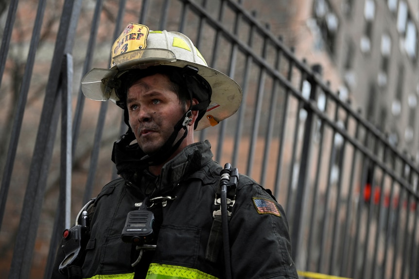 Strażak ma sadzę na twarzy i wygląda na smutnego w Nowym Jorku 