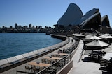 Empty tables in front of the Sydney Opera House.