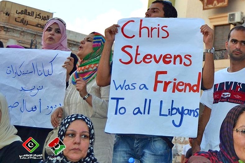 Libyans hold signs protesting the killing of US ambassador, Chris Stevens.