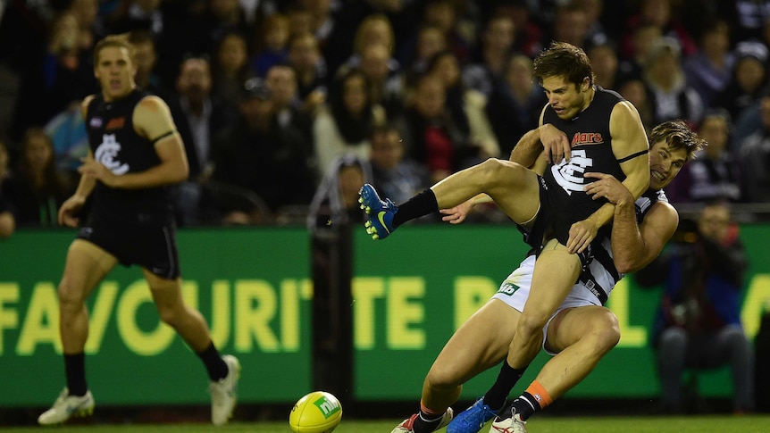 Geelong Cats player Tom Hawkins (right) tackles Carlton Blues player Jason Tutt