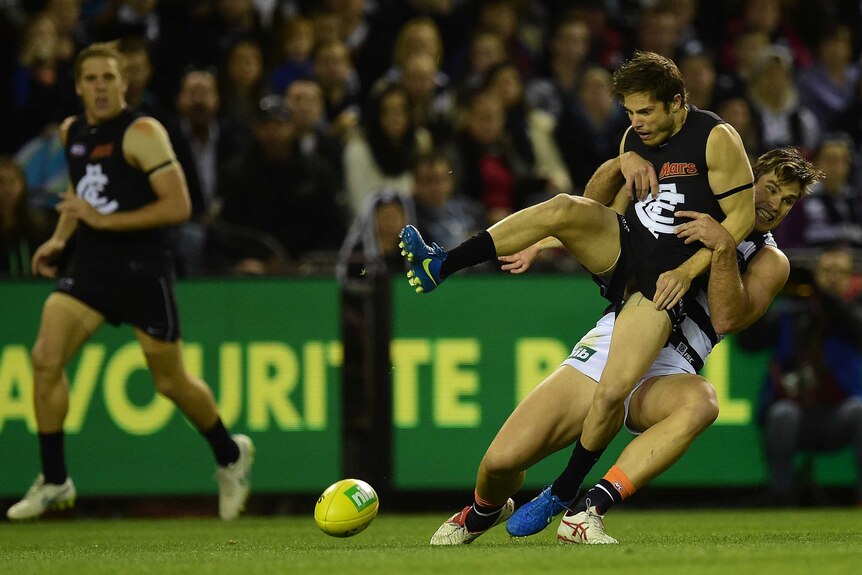 Geelong Cats player Tom Hawkins (right) tackles Carlton Blues player Jason Tutt