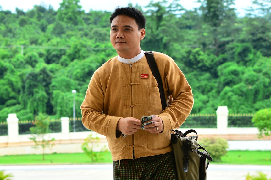 Phyo Zeya Thaw arrives at the Myanmar parliament in yellow shirt with party pin and bag