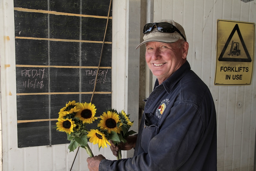 man holding sunflowers