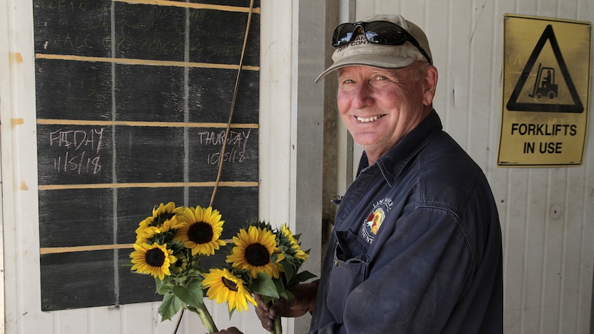 man holding sunflowers