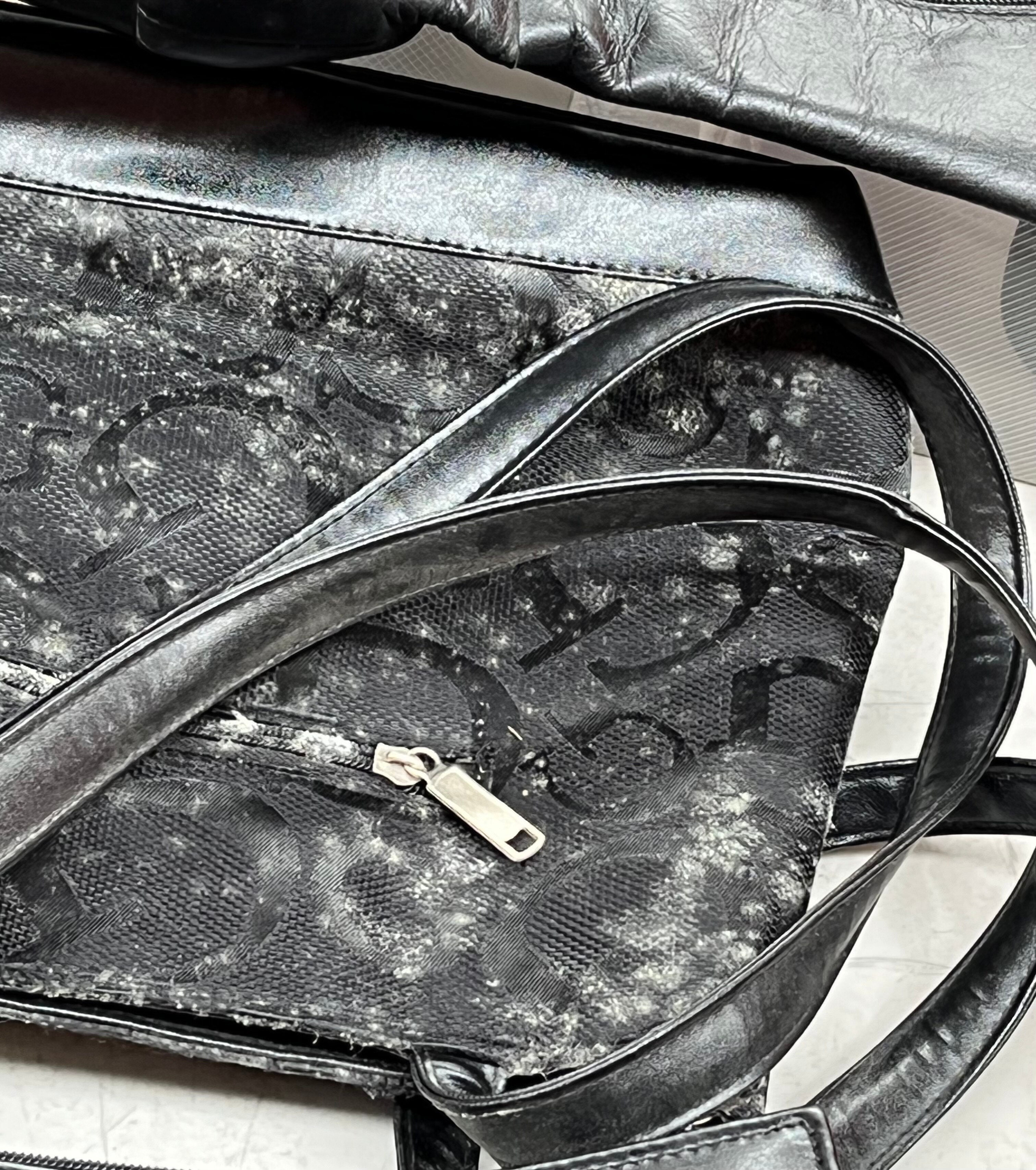 A black handbag covered in mould.