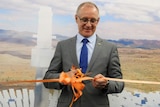 Premier Jay Weatherill cuts a ribbon with scissors.