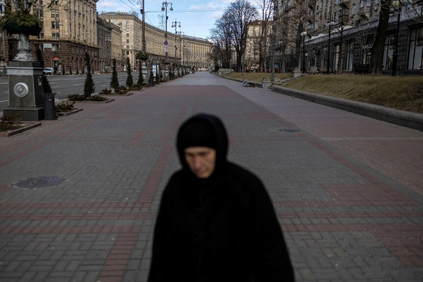 A woman walks the empty city streets.