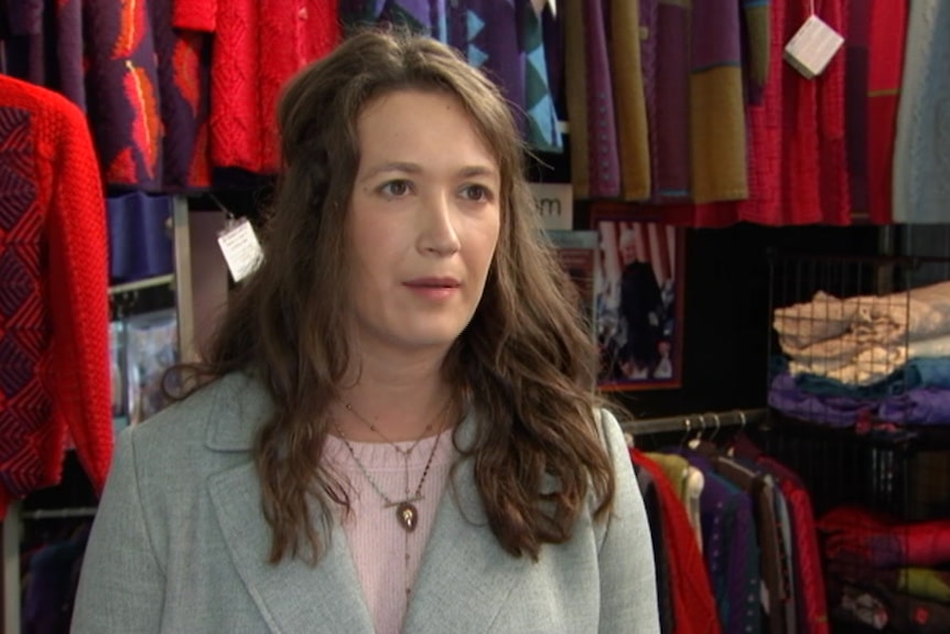 Woman standing in front of various wool products in a shop