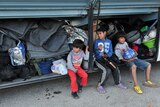 Children wait to leave the refugee camp on the Greek-Macedonia border