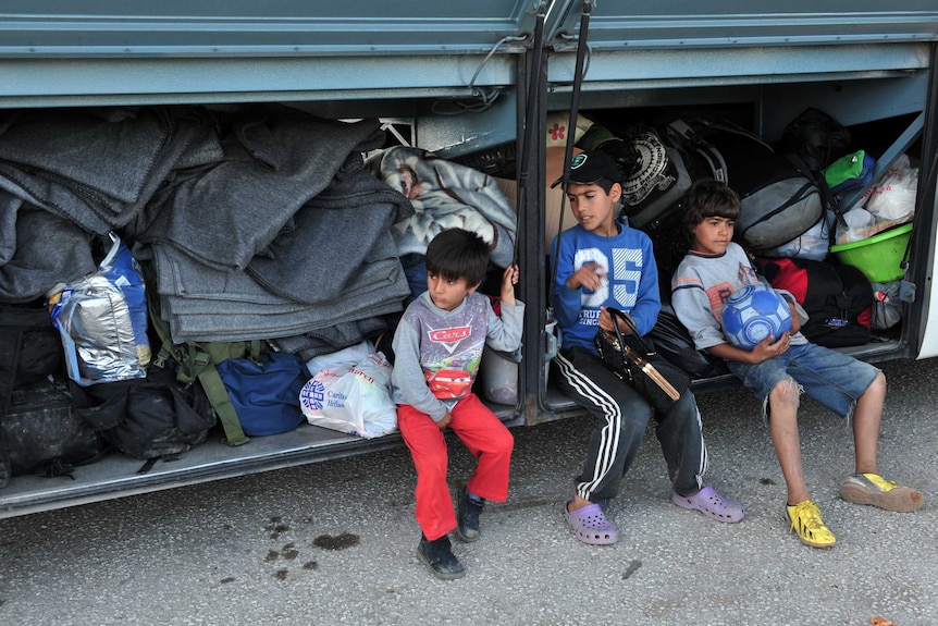 Children it in the boot of a bus waiting to leave a migrant makeshift camp on the Greek-Macedonia border.