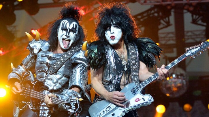 Gene Simmons and Paul Stanley playing together on stage with their shoulders touching