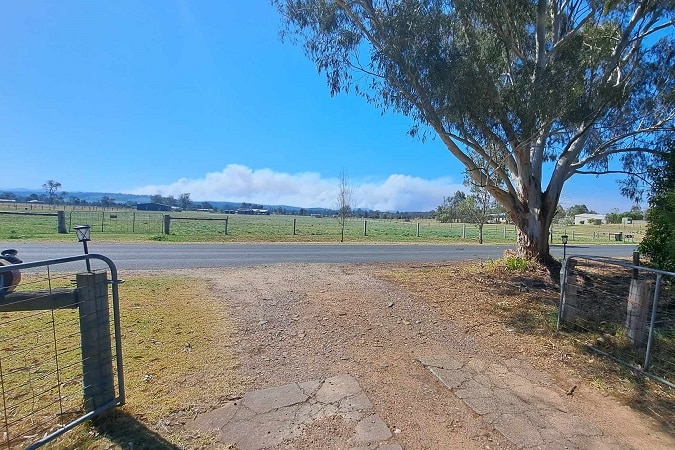 Looking at smoke from a fire in the distance from a front gate at a property in Briagolong.