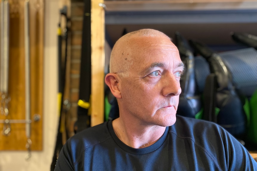 Glen Fearnett looks to the side while sitting in his home gym.