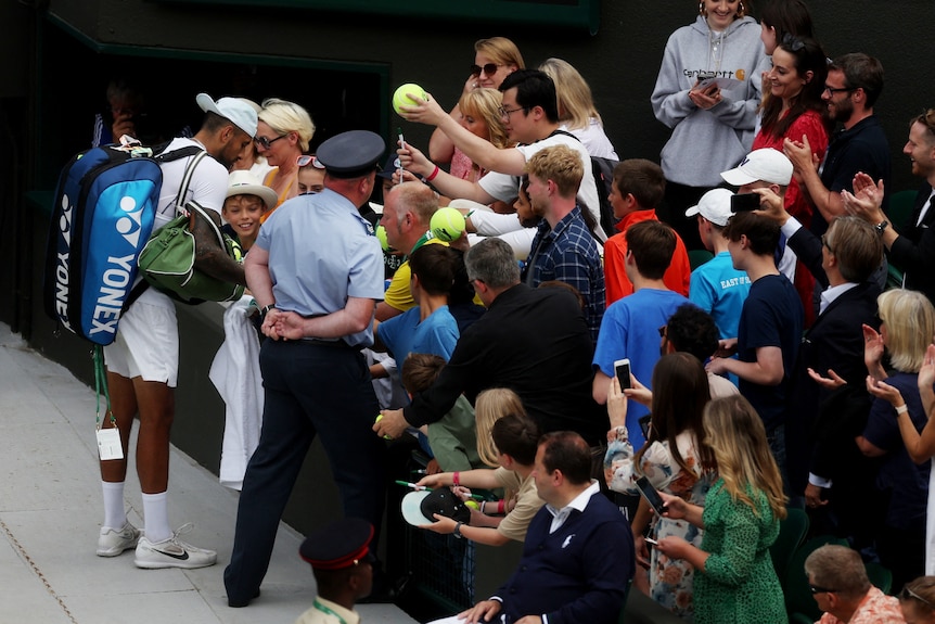 Nick Kyrgios signs autographs at Wimbledon.