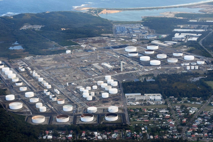 An aerial photo of a large refinery plant next to the ocean