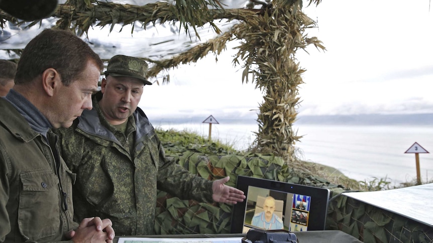 Russian Prime Minister Dmitry Medvedev inspects a machine gun regiment during his visit to Iturup Island.